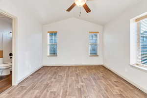 Unfurnished room with light wood-style floors, vaulted ceiling, and ceiling fan