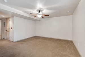 Spare room featuring light carpet and a ceiling fan