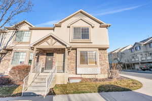 View of front of home featuring stone siding and stucco siding