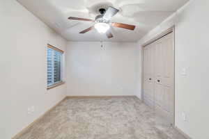 Unfurnished bedroom with carpet floors, a closet, and a ceiling fan