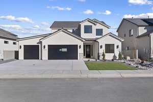 Modern farmhouse with a standing seam roof, concrete driveway, a front lawn, a metal roof, and an attached garage