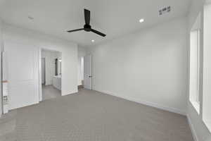 Unfurnished bedroom featuring light carpet, connected bathroom, ceiling fan, and recessed lighting