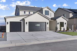 Modern farmhouse featuring driveway and stucco siding