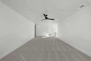 Unfurnished room featuring light colored carpet and a ceiling fan