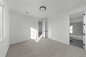 Unfurnished bedroom featuring carpet flooring and ensuite bathroom