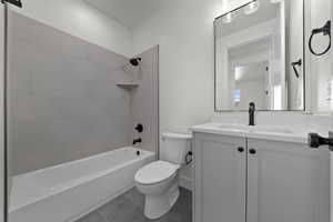Full bath featuring vanity, shower / washtub combination, and dark tile patterned floors