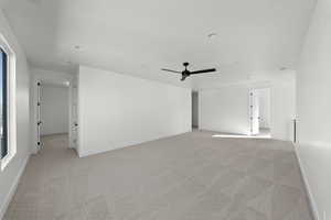 Unfurnished room featuring light colored carpet and a ceiling fan
