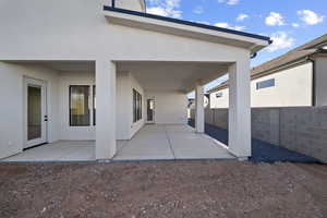 Back of house with stucco siding and a patio