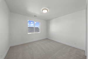 Spare room with light colored carpet and baseboards