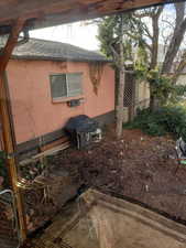 View of side of home featuring concrete block siding and a shingled roof