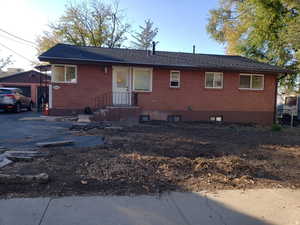 View of front facade featuring brick siding, a garage, and an outdoor structure