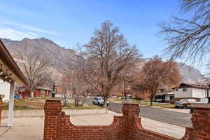 View of asphalt road with a residential view, a mountain view, and sidewalks