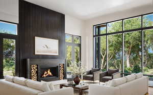 Living area with a towering ceiling and a premium fireplace