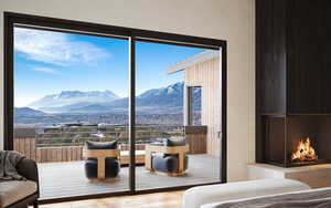 Bedroom with a mountain view, hardwood / wood-style flooring, and a warm lit fireplace