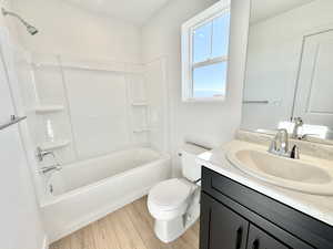 Full bath with vanity, bathing tub / shower combination, and light wood-type flooring