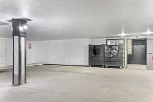 Basement featuring a textured ceiling and elevator