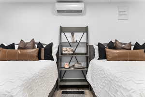 Bedroom featuring a wall mounted AC and light wood-style flooring