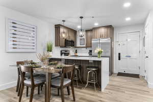 Kitchen with a peninsula, appliances with stainless steel finishes, light stone counters, recessed lighting, and hanging light fixtures