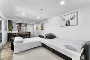 Bedroom with recessed lighting, stainless steel built in fridge, and light wood-style floors