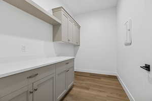 Laundry area featuring dark wood finished floors and electric panel