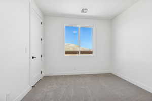 Empty room featuring light colored carpet and baseboards