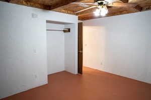 Unfurnished bedroom with concrete flooring, ceiling fan, and a closet