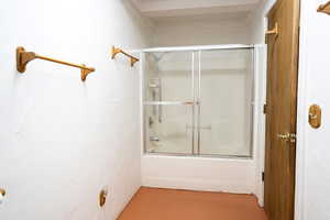 Full bathroom with combined bath / shower with glass door