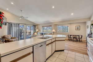 Kitchen featuring open floor plan, light countertops, stainless steel dishwasher, lofted ceiling, and recessed lighting