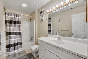 Full bath with shower / bath combo, vanity, and light tile patterned floors