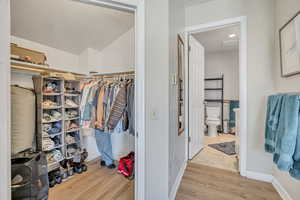 Walk in closet with light wood-type flooring