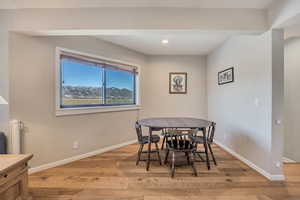 Dining space with light wood-style floors, recessed lighting, and a mountain view