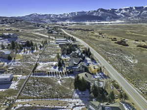 Snowy aerial view featuring a mountain view and a residential view