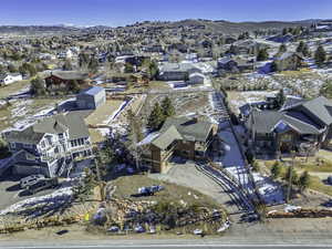 Snowy aerial view featuring a mountain view and a residential view