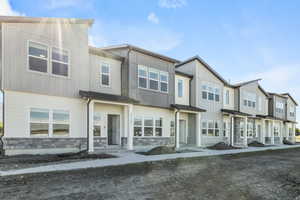 View of front facade with stone siding, a residential view, and board and batten siding