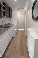 Laundry room featuring light wood-style floors, vaulted ceiling, and recessed lighting