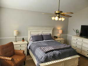 Bedroom featuring dark colored carpet and a ceiling fan