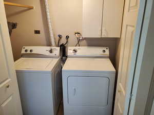 Washroom featuring washing machine and clothes dryer and a textured wall
