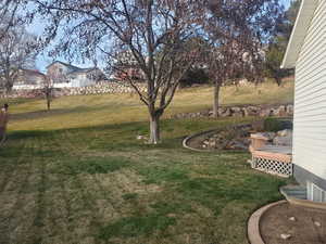 View of green lawn featuring a deck