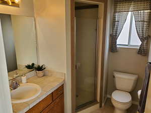 Full bath with a stall shower, vanity, and light tile patterned flooring