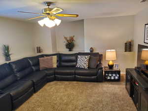 Living room with carpet flooring and a ceiling fan