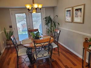 Dining area with wood finished floors and a chandelier