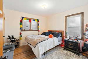 Bedroom with wood finished floors and baseboards