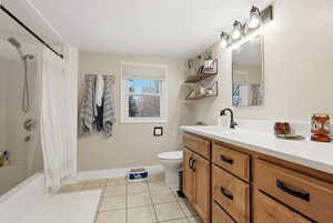Bathroom with shower / bath combination with curtain, vanity, and light tile patterned floors
