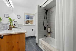 Bathroom featuring shower / bathtub combination with curtain and vanity