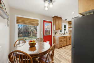 Dining room with light wood-style flooring and recessed lighting