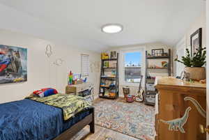 Bedroom featuring vaulted ceiling and light wood-style flooring