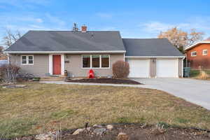 View of front of home with driveway, roof with shingles, and a front yard