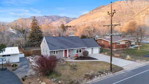 View of front of home with concrete driveway, a mountain view, an attached garage, and roof with shingles