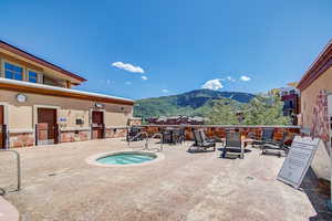 View of pool featuring a mountain view, a patio, and a community hot tub
