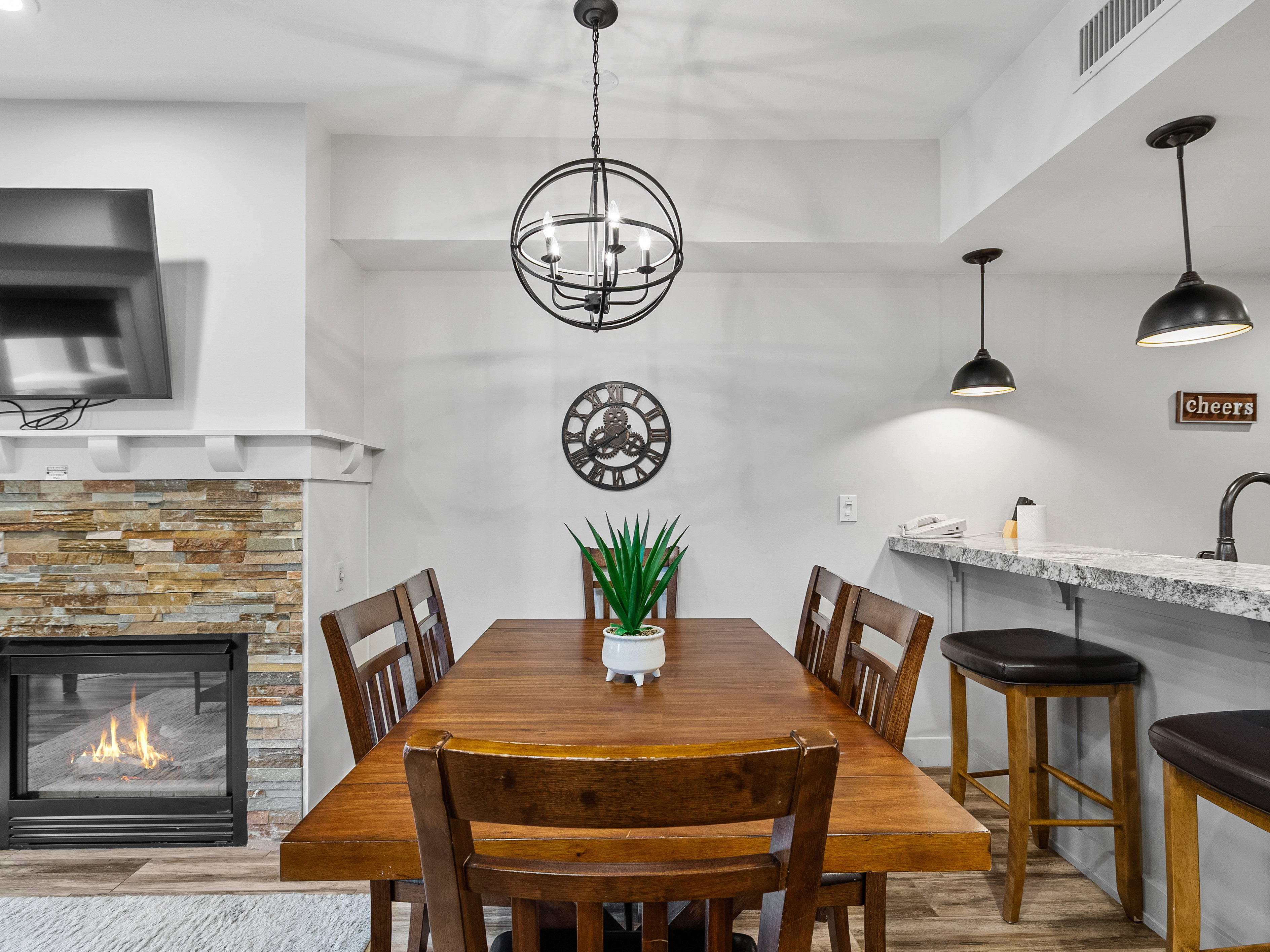 Dining space featuring wood finished floors, a fireplace, and a chandelier